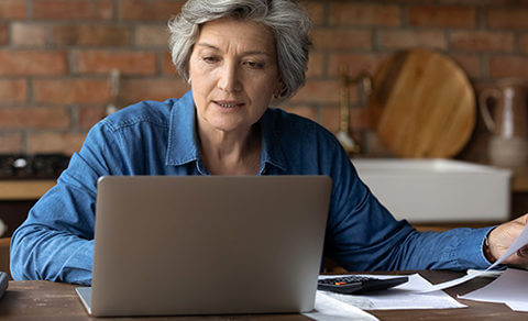 Woman Sitting At A Desk Working On Her Laptop