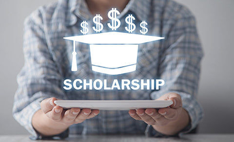 Woman Holding A Paper With An Image Of A Graduation Cap And The Word Scholarship Over It