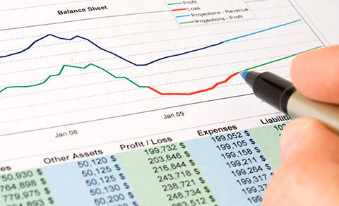 Image Of A Hand Holding A Pen Over A Financial Graph