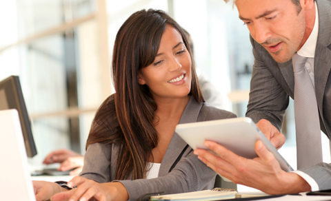 Man And Woman Looking At Work Notes And Having A Discussion