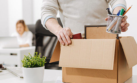 Packing Up Belongings In A Cardboard Box From Work