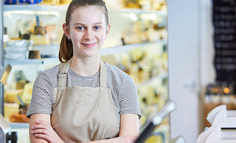 Young Girl Wearing An Apron Working At A Bakery