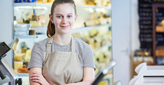 Young Girl Wearing An Apron Working At A Bakery