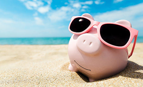Piggy Bank Wearing Sunglasses In The Sand At Thr Beach