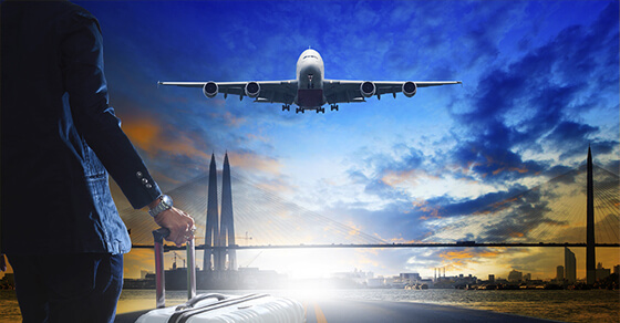 Work or Pleasure: The Tax Rules for Hybrid Travel Backside Of Flight Crew Mwmbwr With Luggage On A Runway Watching A Plane Land