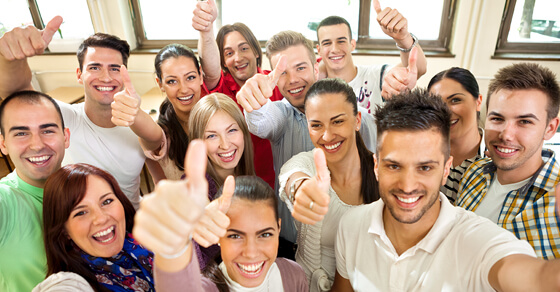 Education Benefits Can Help You Recruit and Retain Smart Employees Classroom Filled With College Students Giving Thumbs Up Sign