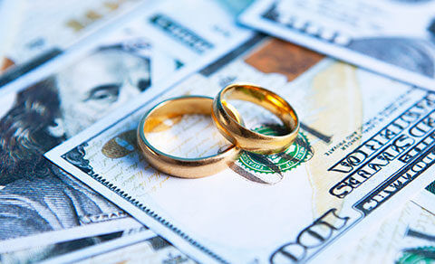 Wedding Rings On Top Of A Pile Of Cash