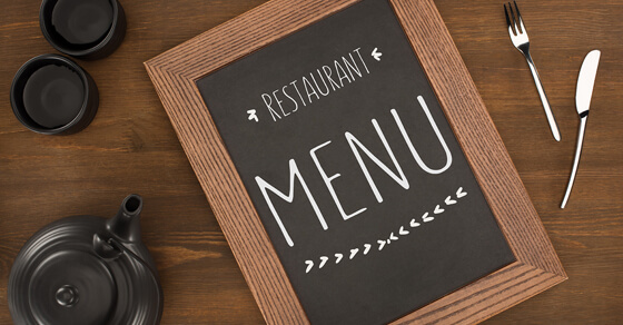 Chalk Restaurant Menu Surrounded By A Teapot, Cups And A Knife And Fork