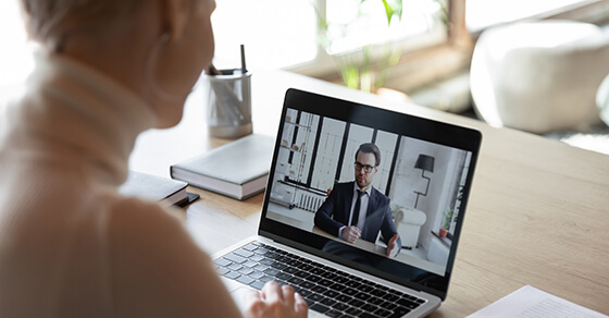 Woman At A Desk On A Zoom Meeting With A Male Businessman