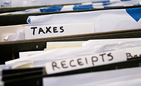 Files in a cabinet, one file labeled Taxes and another file labeled Receipts