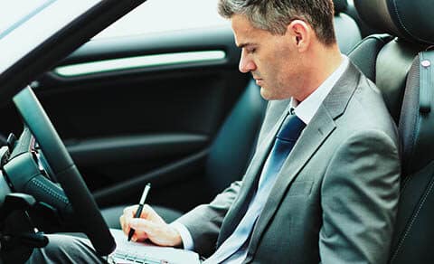 Businessman,sitting,in,his,car,,he,is,planning,and,scheduling