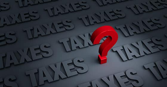 Red question mark on a dark grey background with the word Taxes