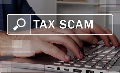 Hands typing on keybard with the headline TAX SCAM