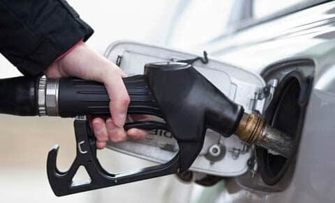 Close up of a man's hand holding gas pump and filling up his car