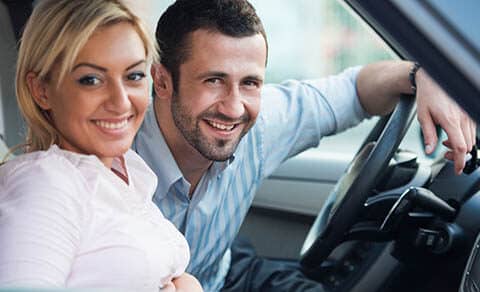 Smiling,young,couple,posing,sitting,in,a,car