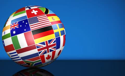 Globe covered in various covered flags on a blue background