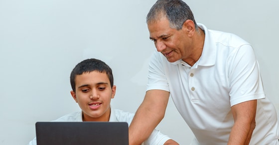 Father and son working together on a laptop