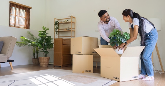 Married couple packing their living room into boxes as they prepare to move