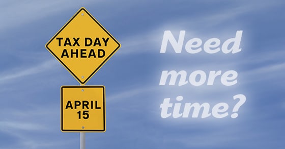 Blue sky with clouds, yellow yield street sign that says Tax Day Ahead April 15, Need more time written in the sky