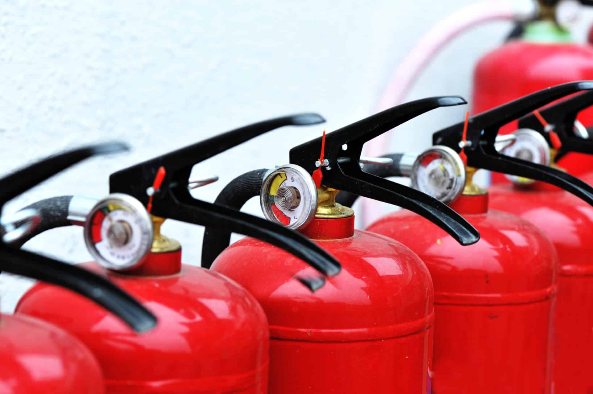 Close up of bright red fire extinguishers in a row