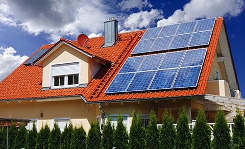 Outside of a house with orange roof that has solar panels