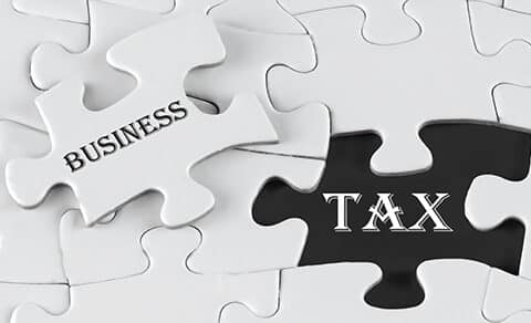 A, puzzle, with, a, missing, piece,, where, the, visible, black, space, reads, 'TAX,' and, the, puzzle, piece, being, placed, reads, 'BUSINESS,' symbolizing, the, connection, between, business, and, taxes.