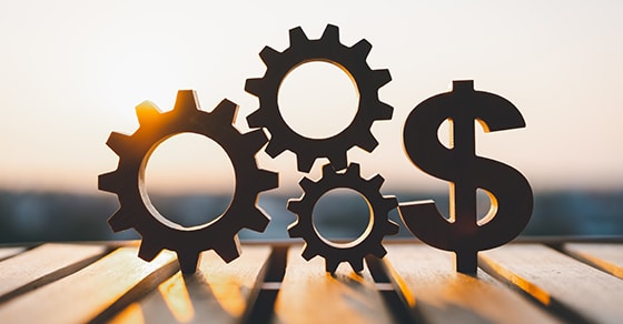 ChatGPT said: Silhouettes, of, three, interlocking, gears, and, a, dollar, sign, symbolizing, business, finance, and, operational, efficiency, with, a, warm, sunrise, or, sunset, in, the, background.
