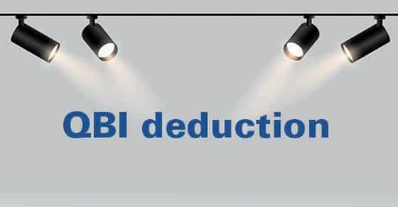 Four, black, spotlights, shine, down, on, the, bold, blue, text, “QBI, deduction”, against, a, light, gray, background, emphasizing, its, importance.