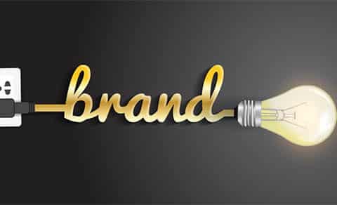 The word “brand” forms a cord plugged into a glowing light bulb.