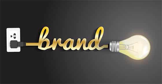 The word “brand” forms a cord plugged into a glowing light bulb.