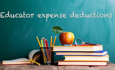 Chalkboard, with, “Educator, expense, deductions,” books, apple, magnifying, glass, pencils, classroom, education.