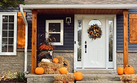 Front porch, fall decor, pumpkins, hay bales, wreath, white door, cozy home, autumn vibes.