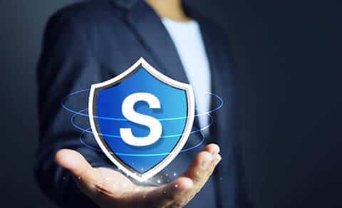 Businessman,holding,a,shield,in,his,hand,to,mean,protecting