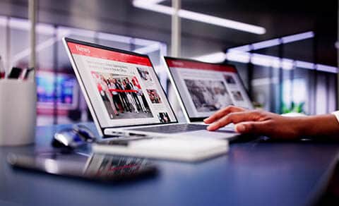 American,woman,views,online,news,articles,on,laptop,and,phone