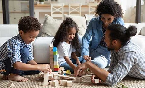Family, sitting, together, on, the, floor, building, with, wooden, blocks, children, focused, parents, engaged, smiling, cozy, living, room, joyful, moment,