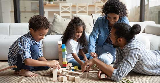 Family, sitting, together, on, the, floor, building, with, wooden, blocks, children, focused, parents, engaged, smiling, cozy, living, room, joyful, moment,